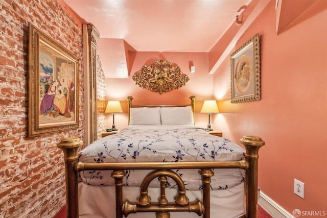 bedroom with brick wall and carpet flooring