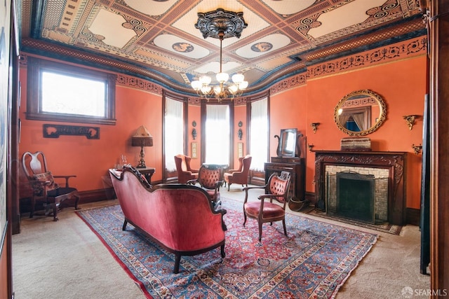living area featuring a brick fireplace, carpet flooring, and an inviting chandelier