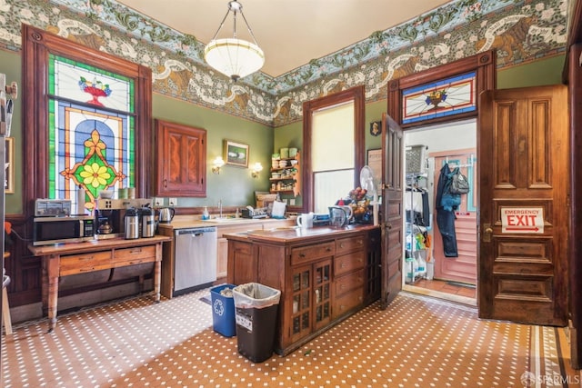 kitchen with sink, pendant lighting, kitchen peninsula, and stainless steel appliances