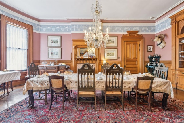 dining space with a notable chandelier, ornamental molding, and hardwood / wood-style floors