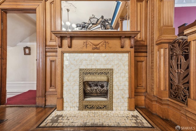 details with wood finished floors and a tile fireplace