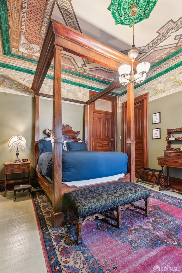 bedroom featuring hardwood / wood-style floors and ceiling fan with notable chandelier