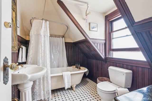 bathroom with toilet, shower / bathtub combination with curtain, and wooden walls