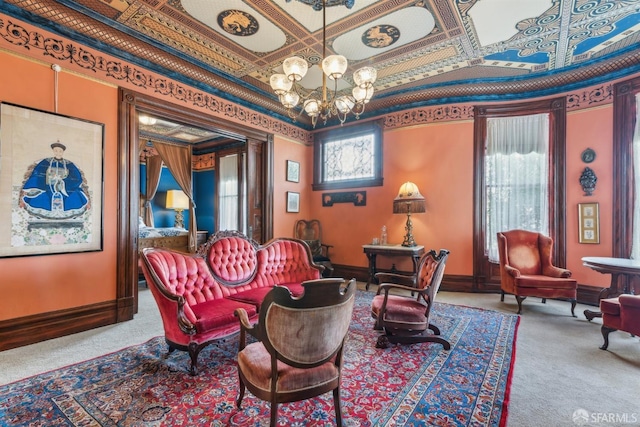 living area with baseboards, an ornate ceiling, carpet flooring, and a chandelier