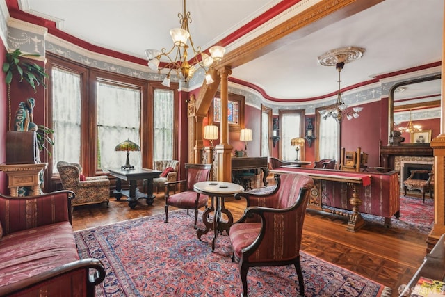 living area featuring decorative columns, ornamental molding, a chandelier, and dark parquet flooring