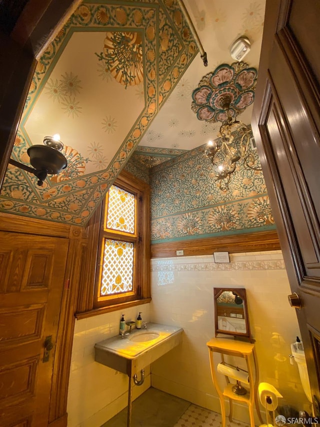 bathroom with a sink and wallpapered walls