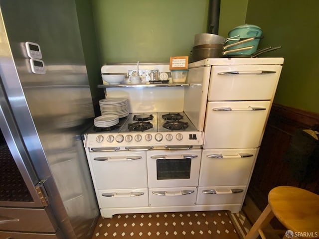 kitchen with freestanding refrigerator and range with two ovens