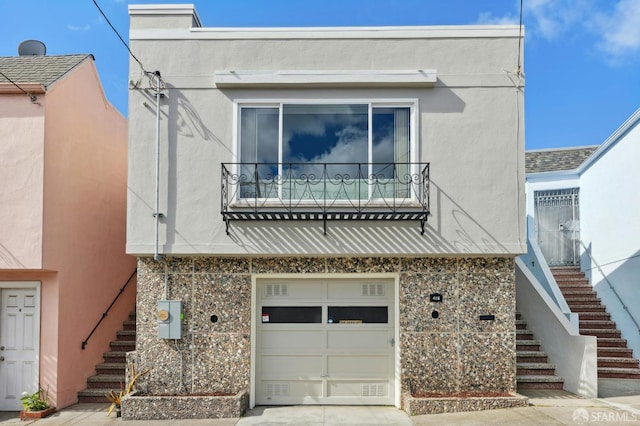 view of front of property with stucco siding, driveway, an attached garage, and stairs