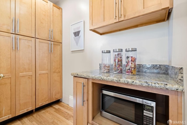 interior space featuring light stone counters, light hardwood / wood-style floors, and light brown cabinets