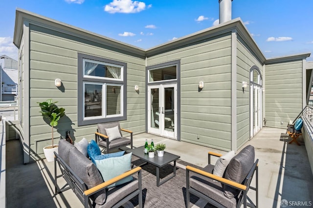 rear view of house with an outdoor living space, a patio, and french doors