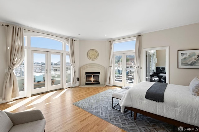 bedroom featuring french doors, access to exterior, and hardwood / wood-style flooring