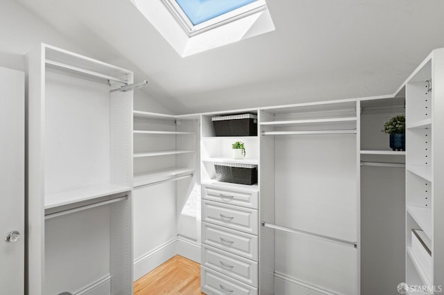 walk in closet with hardwood / wood-style flooring and vaulted ceiling