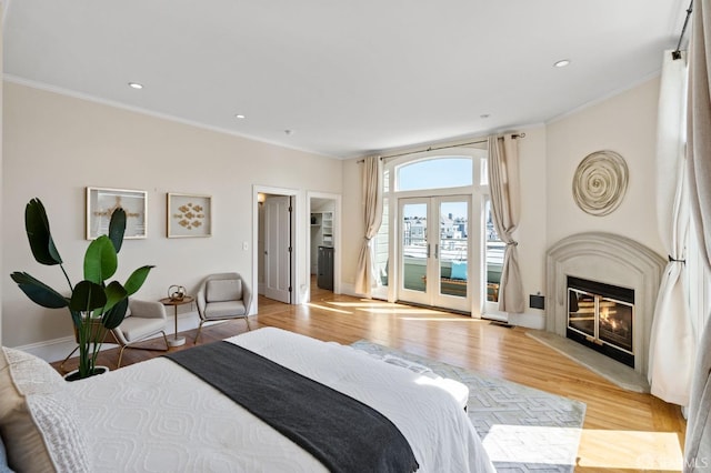 bedroom featuring french doors, ornamental molding, access to exterior, and light hardwood / wood-style flooring