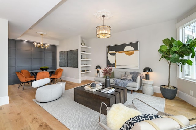 living room featuring a chandelier and light hardwood / wood-style flooring