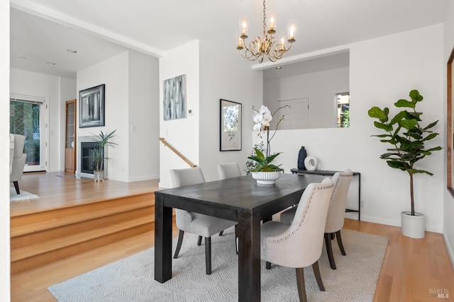 dining room with light hardwood / wood-style floors and a notable chandelier