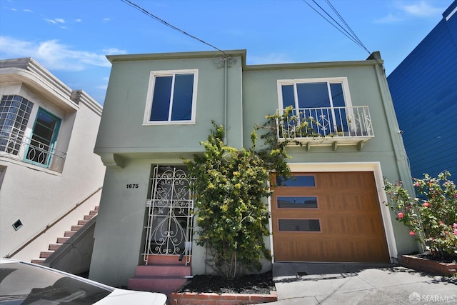 1675 Quint St, San Francisco, CA 94124 - view of front of home featuring stucco siding, an attached garage, driveway, and a balcony