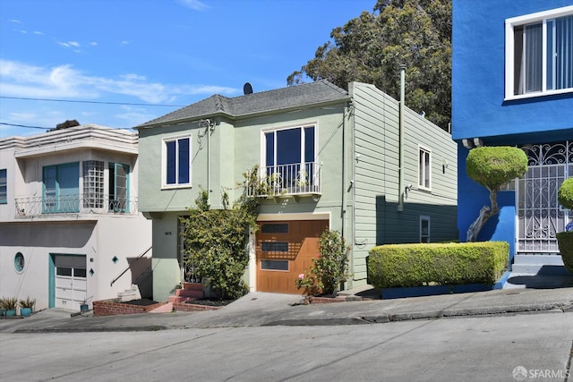 1675 Quint St, San Francisco, CA 94124 - view of front facade with a balcony, a garage, and stucco siding