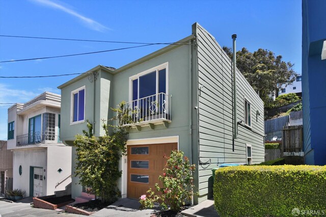 1675 Quint St, San Francisco, CA 94124 - view of front facade featuring a balcony, a garage, and stucco siding