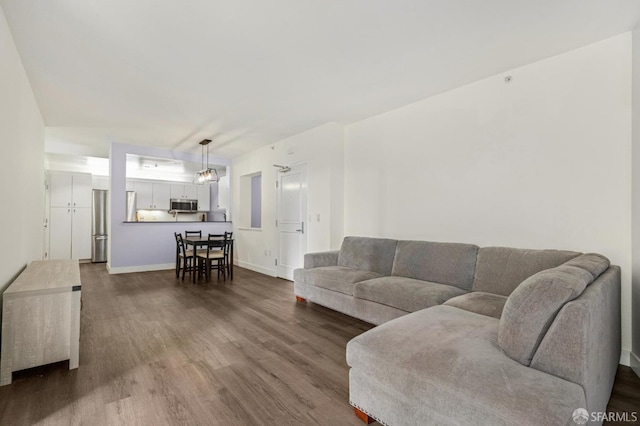 living room with a chandelier and dark wood-type flooring