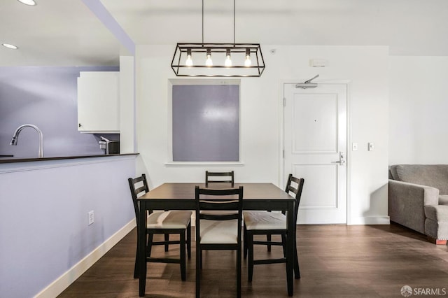 dining space featuring sink and dark wood-type flooring