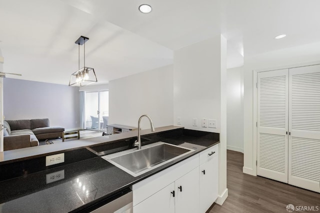 kitchen with dark hardwood / wood-style floors, sink, white cabinets, decorative light fixtures, and stainless steel dishwasher