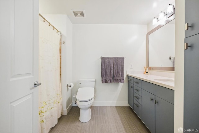 bathroom with curtained shower, vanity, and toilet