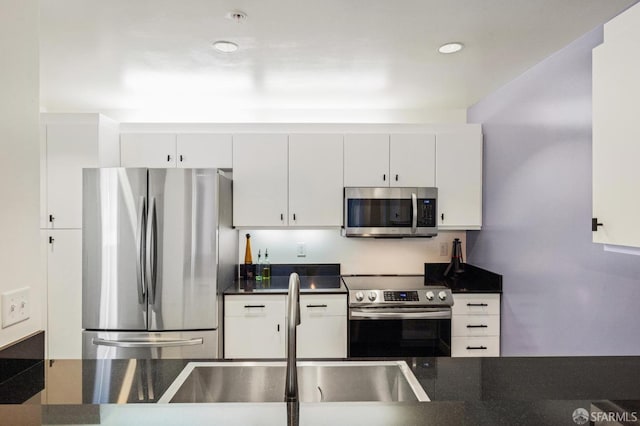 kitchen featuring stainless steel appliances, sink, and white cabinetry