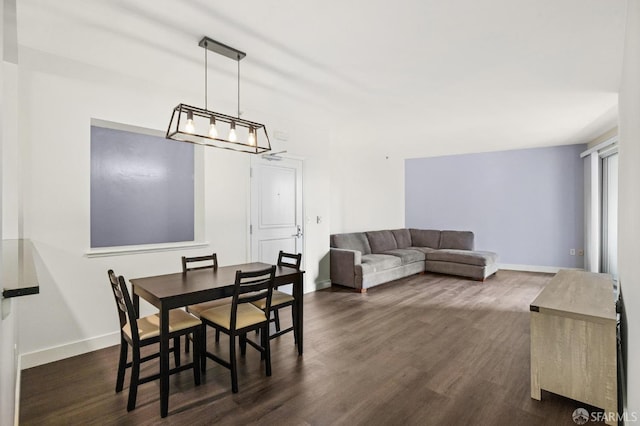 dining room featuring a notable chandelier and dark wood-type flooring