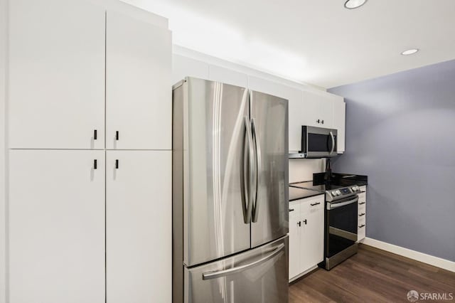 kitchen featuring white cabinets, stainless steel appliances, and dark wood-type flooring