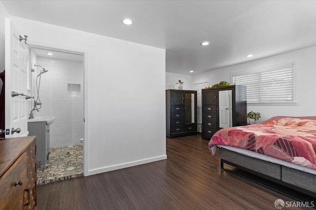 bedroom featuring connected bathroom, dark hardwood / wood-style floors, and sink