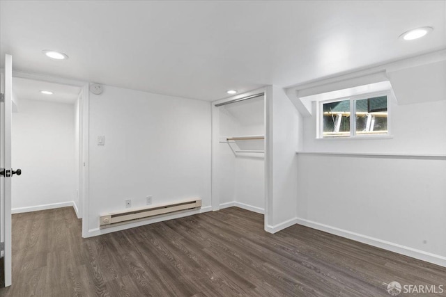 unfurnished room with a baseboard radiator and dark hardwood / wood-style flooring