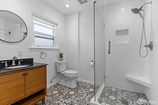 bathroom featuring tile patterned floors, vanity, toilet, and a shower with shower door