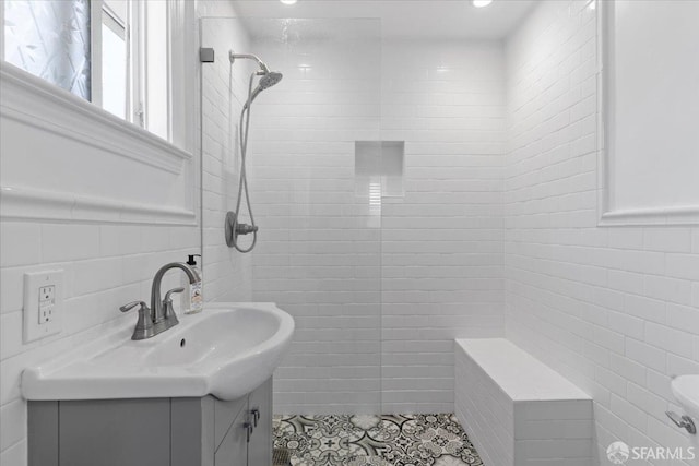 bathroom featuring tile walls, vanity, and tiled shower