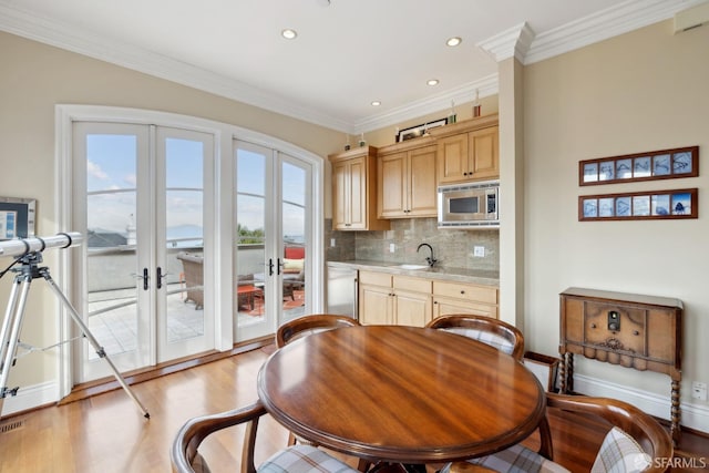 kitchen with sink, stainless steel microwave, ornamental molding, french doors, and light brown cabinets