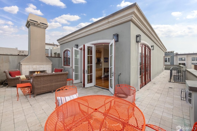 view of patio / terrace with an outdoor living space with a fireplace