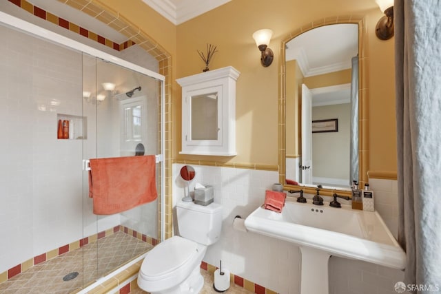 bathroom featuring ornamental molding, toilet, and a shower with door