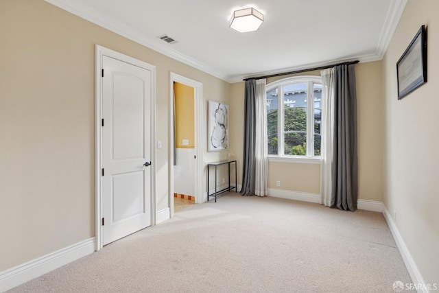 empty room featuring crown molding and light colored carpet