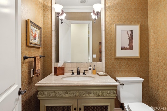 bathroom featuring vanity, ornamental molding, and toilet