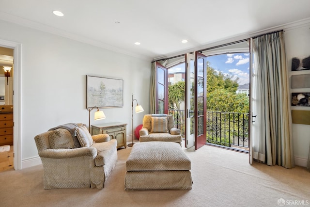 living area featuring light carpet, a wealth of natural light, and ornamental molding