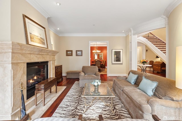 living room featuring crown molding, a high end fireplace, hardwood / wood-style floors, and a chandelier