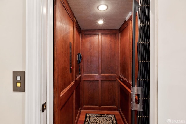 interior details featuring a textured ceiling and elevator