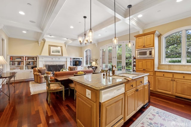 kitchen with pendant lighting, stainless steel microwave, beamed ceiling, dishwasher, and a kitchen island with sink