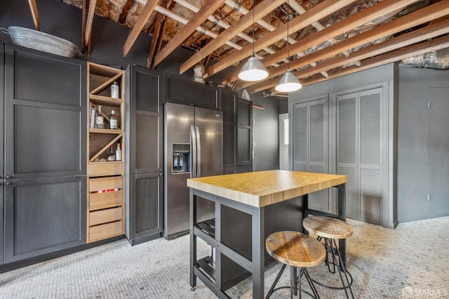 kitchen with light colored carpet, butcher block counters, pendant lighting, and stainless steel fridge with ice dispenser