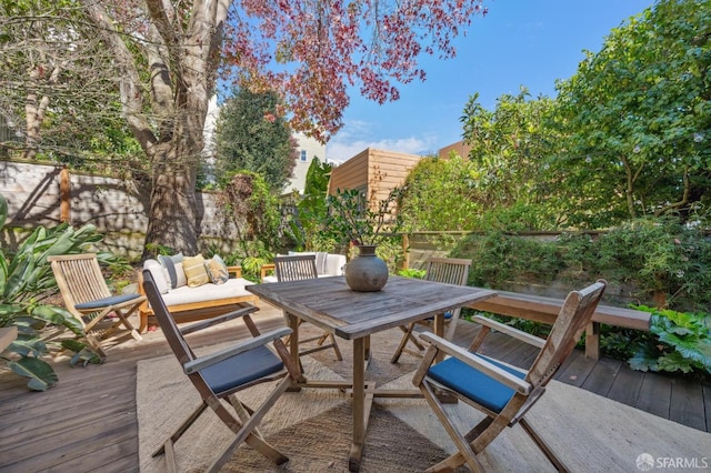 view of patio with outdoor lounge area, a wooden deck, outdoor dining area, and fence