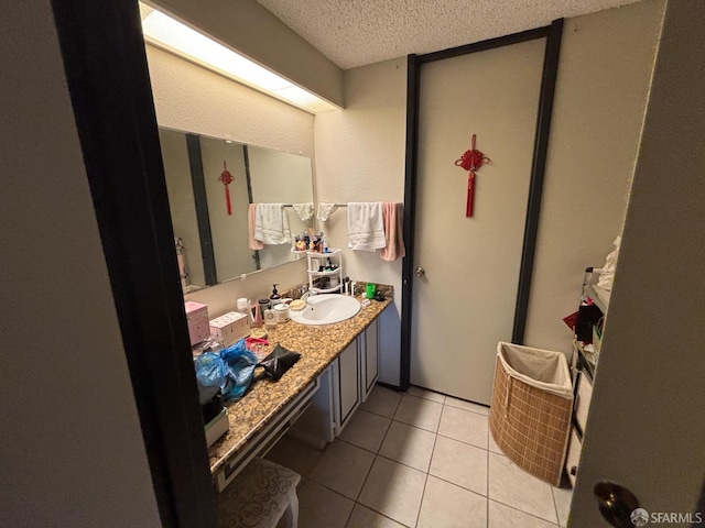 bathroom featuring tile patterned flooring, vanity, and a textured ceiling