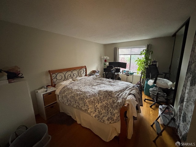 bedroom featuring wood-type flooring and a textured ceiling