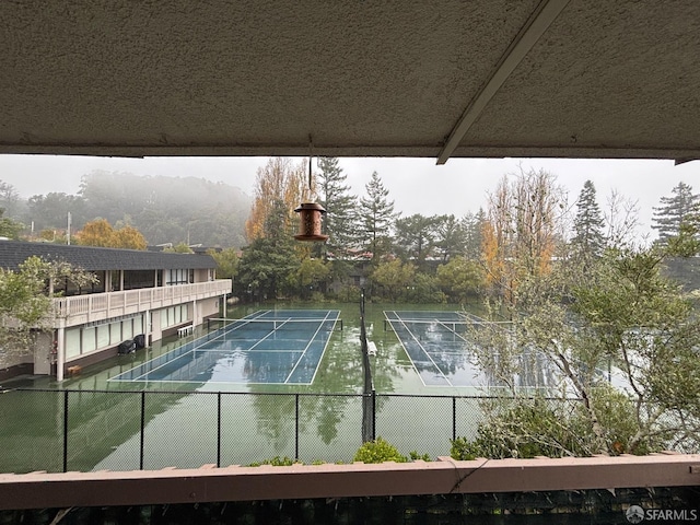 view of swimming pool with tennis court