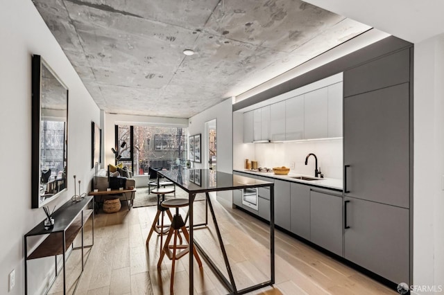 kitchen with modern cabinets, light wood-type flooring, a sink, and gray cabinetry