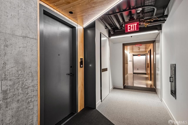 hallway featuring baseboards and carpet flooring