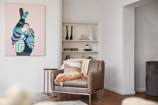 sitting room featuring built in shelves and wood-type flooring